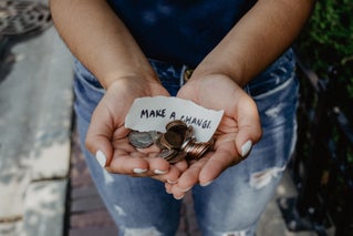 woman holding change and "make a change" sign