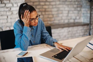 Woman frustrated as she uses a laptop