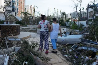 two people walking through the ruined street