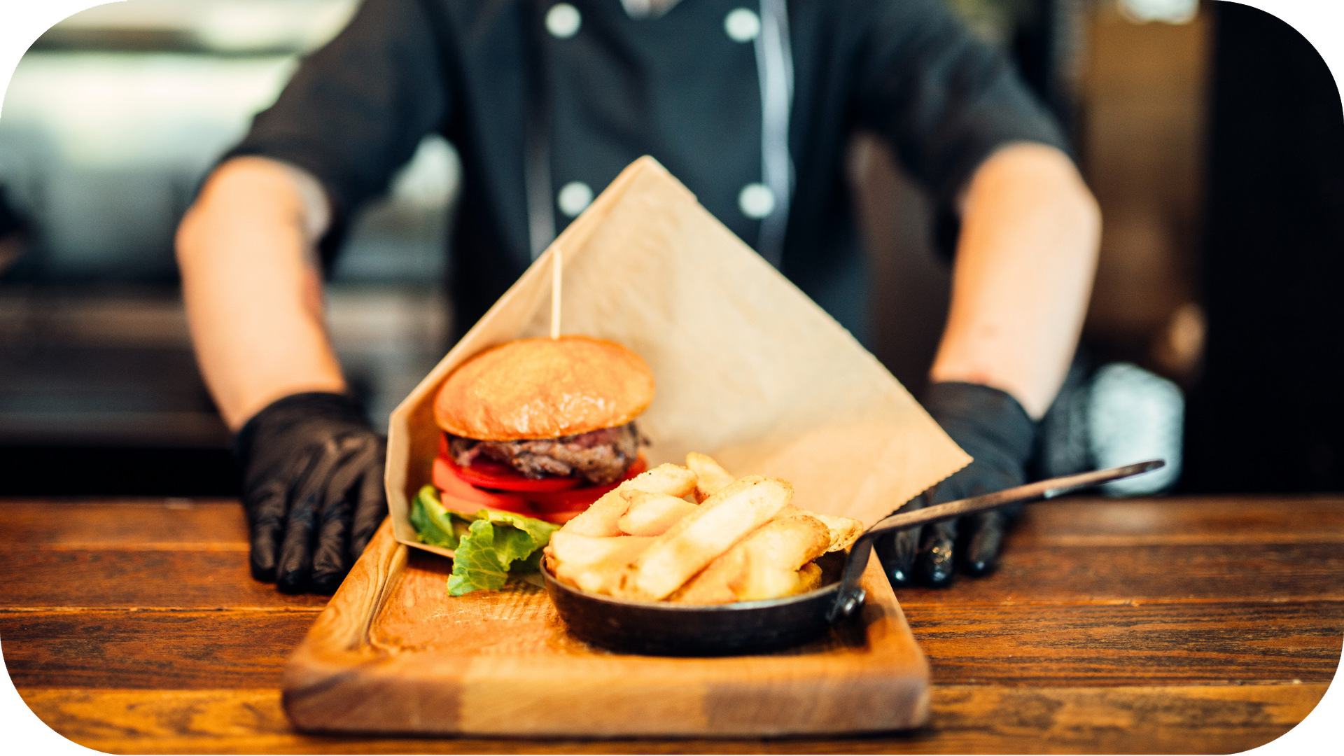 Server presenting a burger and fries at a restaurant